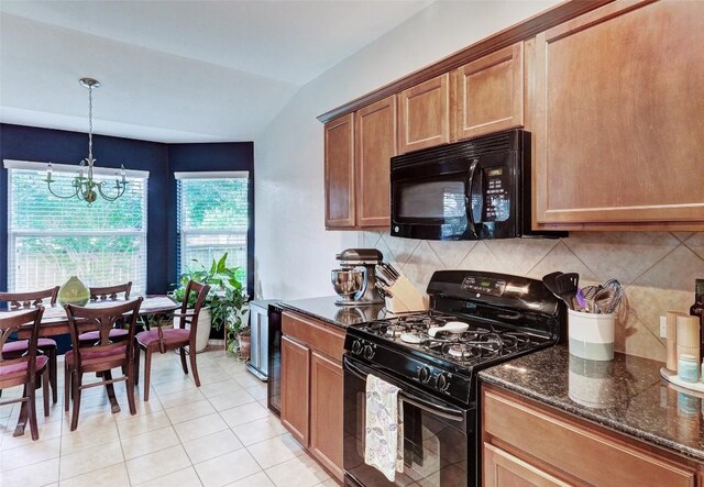 kitchen with an inviting chandelier, dark stone counters, black appliances, hanging light fixtures, and vaulted ceiling