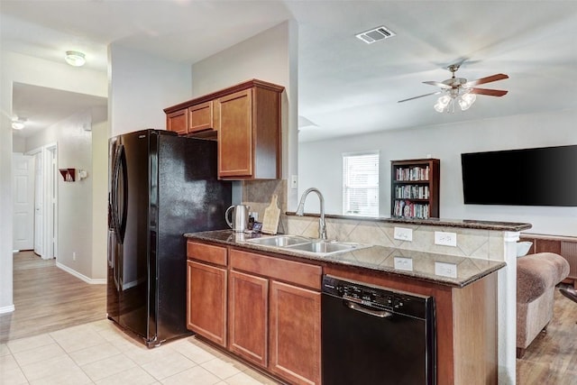 kitchen featuring dark stone counters, black appliances, decorative backsplash, light tile patterned flooring, and ceiling fan