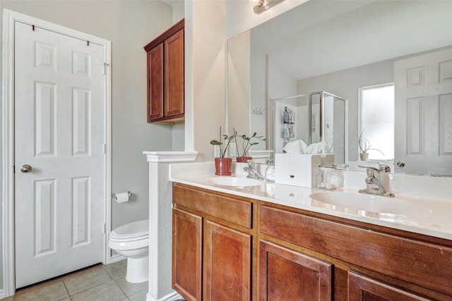 bathroom featuring tile patterned floors, double sink vanity, and toilet