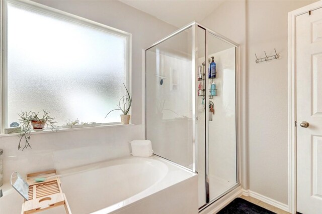 bathroom with separate shower and tub and a wealth of natural light