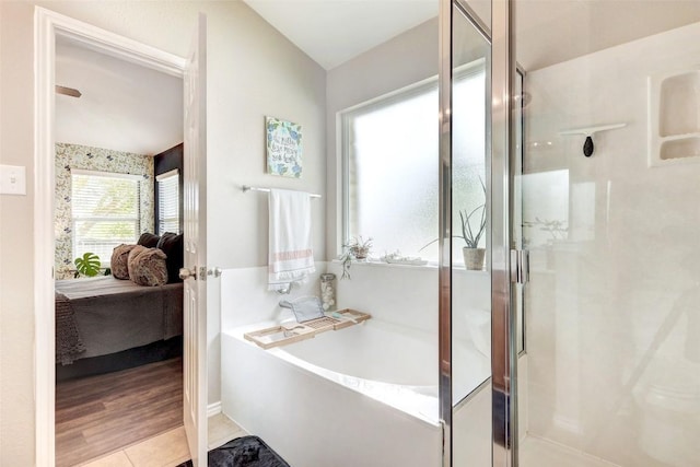 bathroom featuring tile patterned flooring, vaulted ceiling, and separate shower and tub