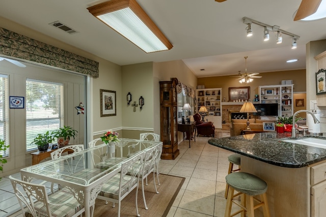 tiled dining room featuring sink, ceiling fan, and track lighting