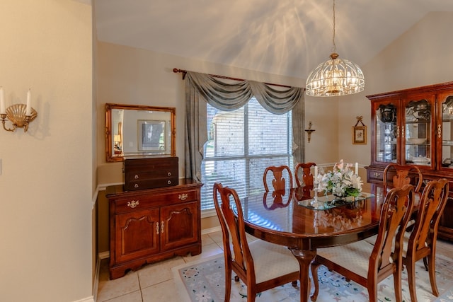 dining room with an inviting chandelier, vaulted ceiling, and light tile patterned floors