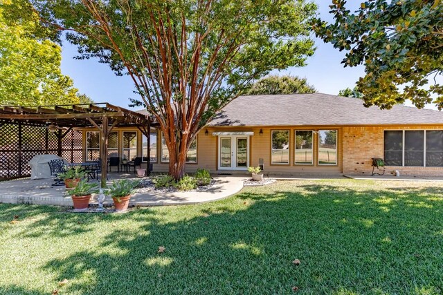 back of property featuring french doors, a patio area, a lawn, and a pergola