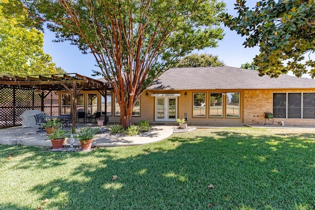 back of property with french doors, a pergola, a lawn, and a patio area