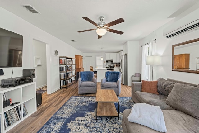 living room with ceiling fan, dark hardwood / wood-style flooring, and a wall unit AC