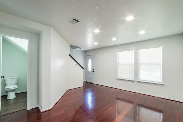 entryway with dark wood-type flooring and a textured ceiling