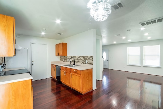 kitchen with dark wood-type flooring, black dishwasher, decorative backsplash, stove, and sink