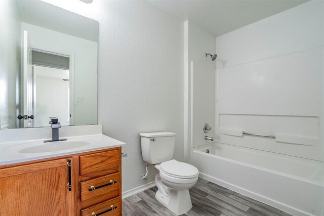 full bathroom featuring wood-type flooring,  shower combination, toilet, and vanity