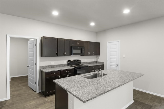 kitchen featuring an island with sink, sink, dark wood-type flooring, and black appliances