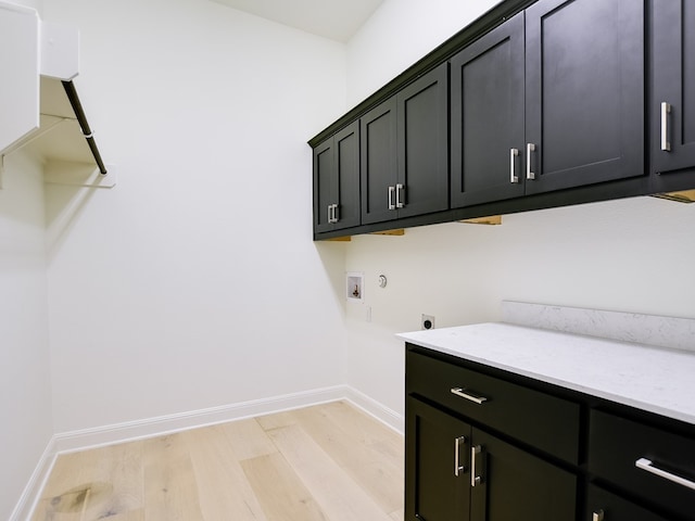 clothes washing area with cabinets, hookup for a washing machine, light hardwood / wood-style floors, and electric dryer hookup