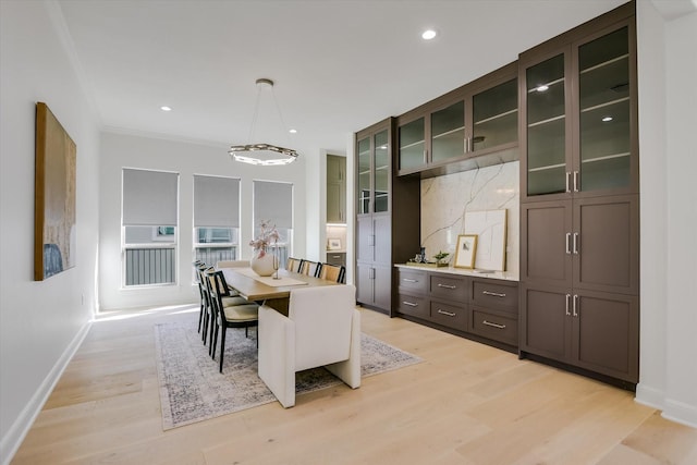 dining area with crown molding and light wood-type flooring