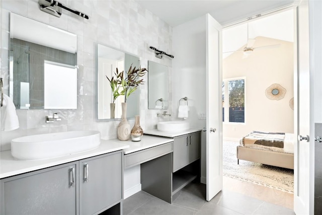 bathroom featuring ceiling fan, tile patterned flooring, tile walls, vanity, and tasteful backsplash