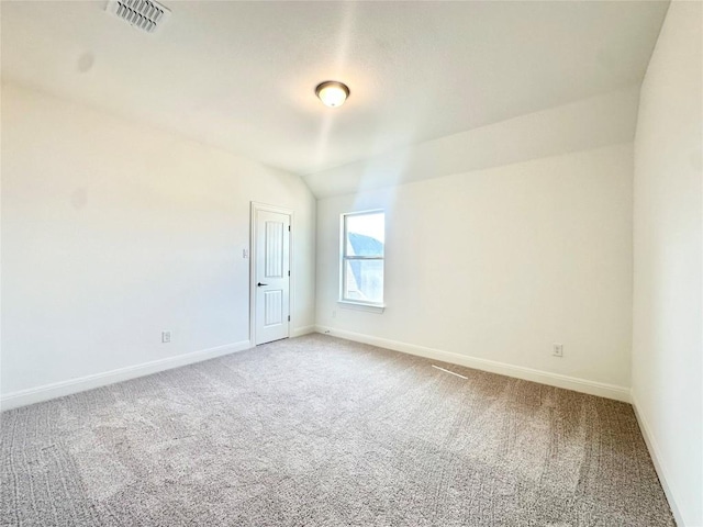 empty room with visible vents, baseboards, carpet, and vaulted ceiling