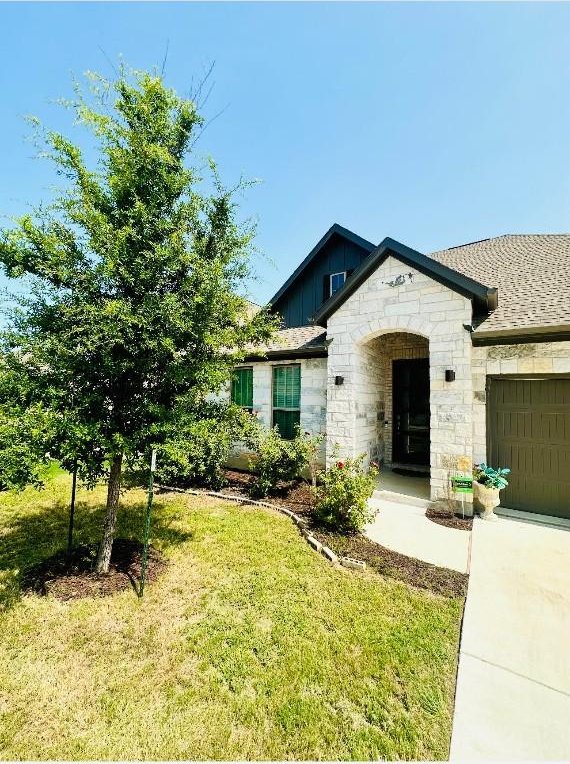 view of front of property featuring a garage and a front lawn