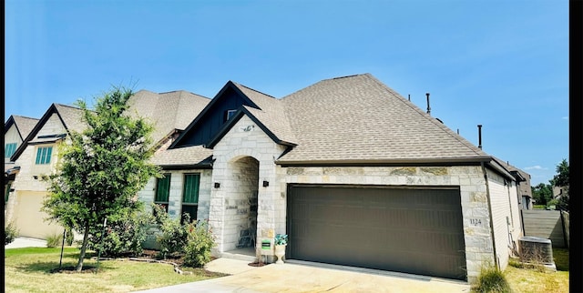 french country style house with a garage and a front yard