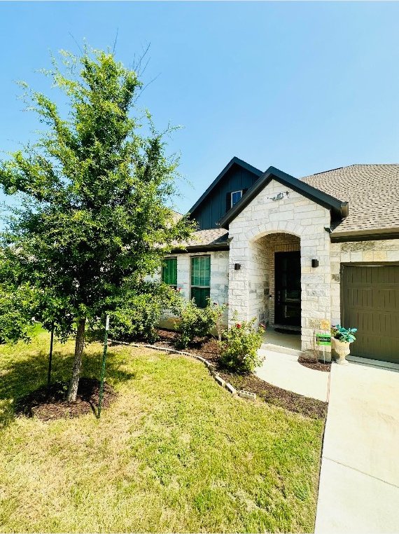 view of front of home featuring a garage and a front yard