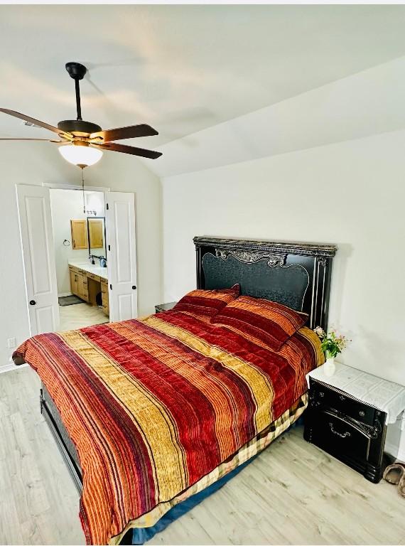 bedroom featuring lofted ceiling, light hardwood / wood-style flooring, ceiling fan, and ensuite bathroom