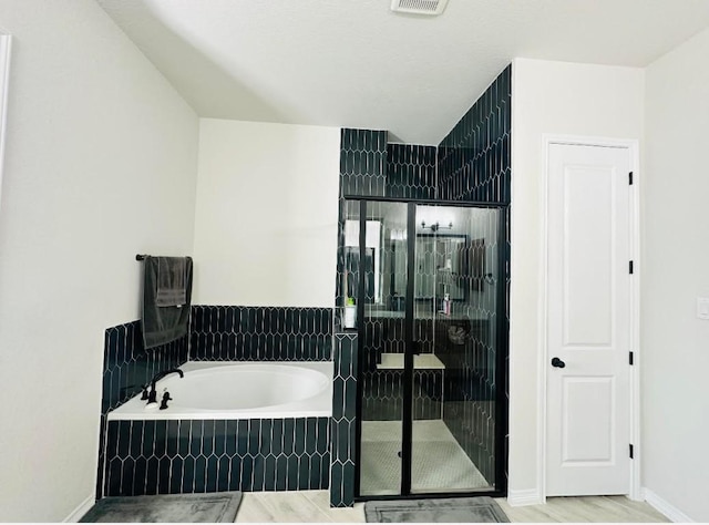 bathroom featuring separate shower and tub