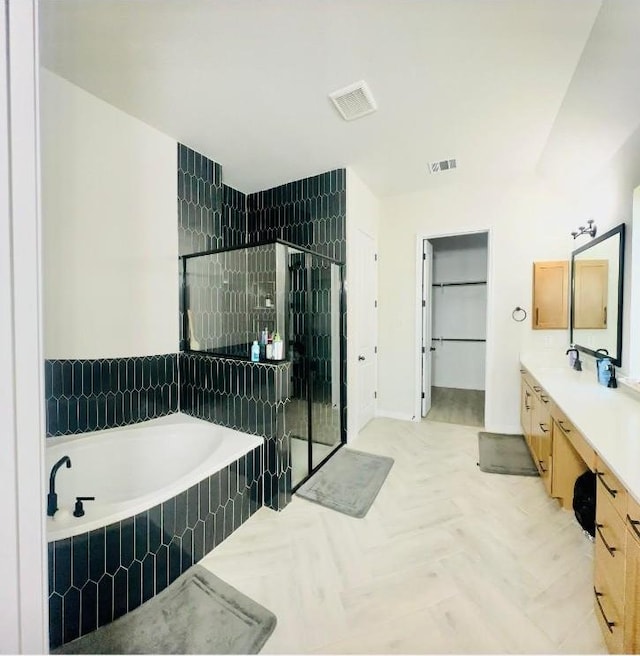 bathroom featuring parquet floors, vanity, and plus walk in shower