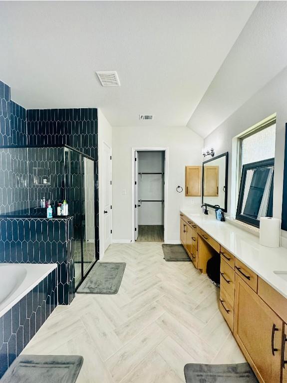 bathroom with vanity, parquet floors, and plus walk in shower