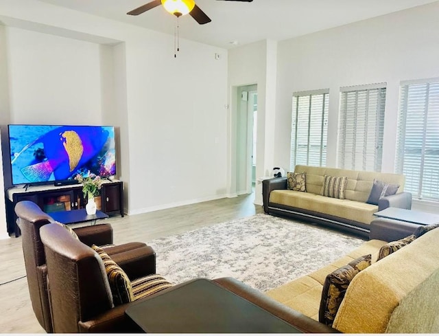 living room with ceiling fan, a healthy amount of sunlight, and light wood-type flooring