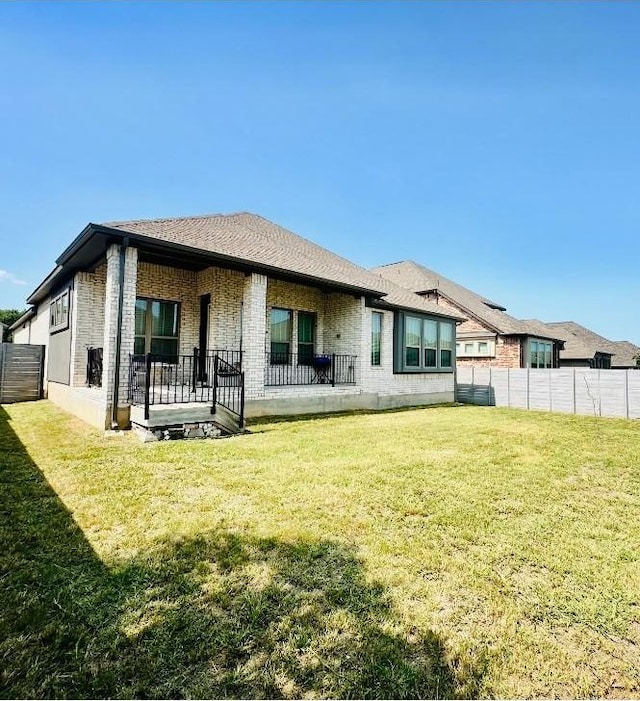 rear view of property with a yard