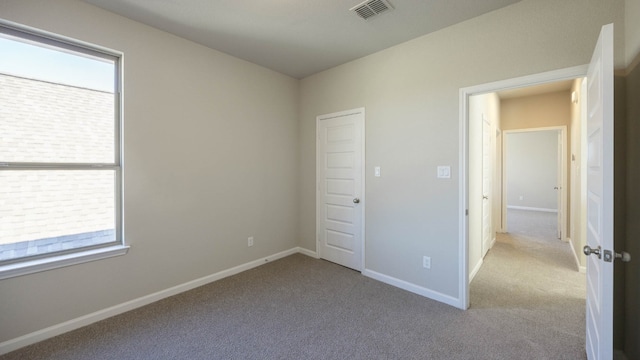 unfurnished bedroom featuring light carpet