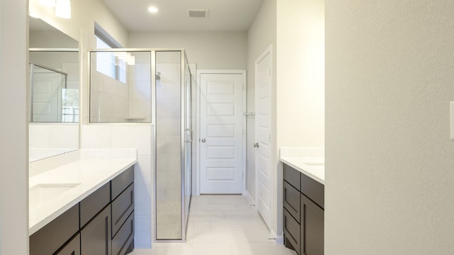 bathroom featuring vanity, tile patterned floors, and a shower with shower door