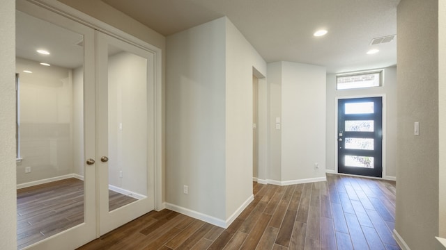 foyer with french doors and dark hardwood / wood-style floors