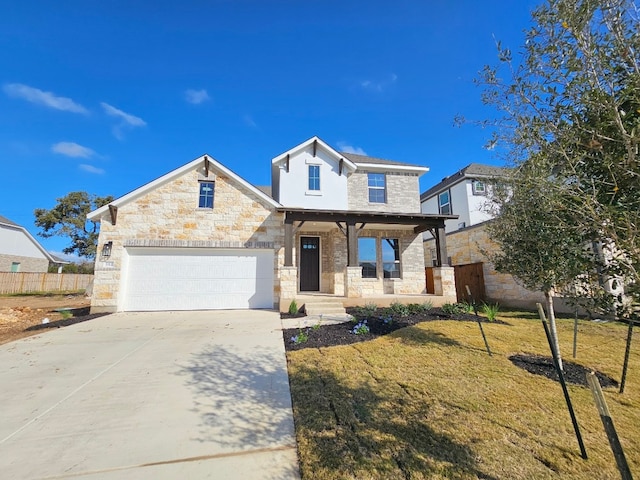 view of front of house featuring covered porch, a garage, and a front yard