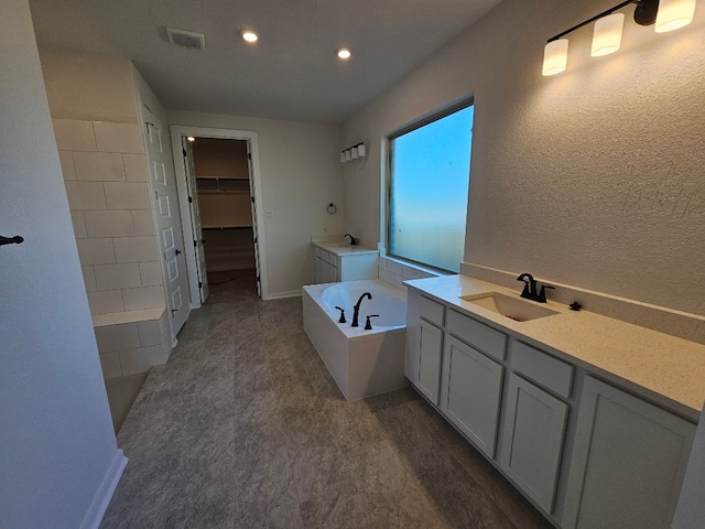 bathroom featuring vanity and a tub to relax in