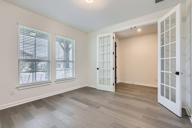 unfurnished room with french doors and hardwood / wood-style floors