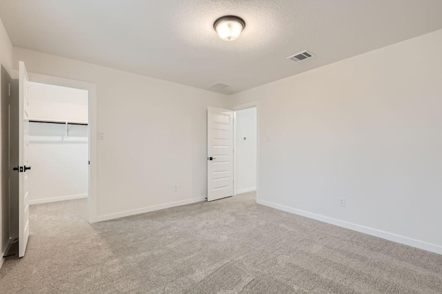 carpeted spare room featuring a textured ceiling