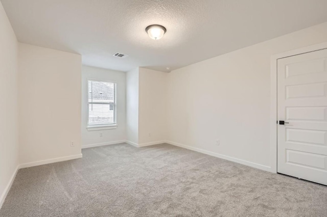 carpeted spare room with a textured ceiling