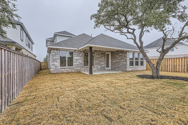 back of house featuring a lawn and a patio area