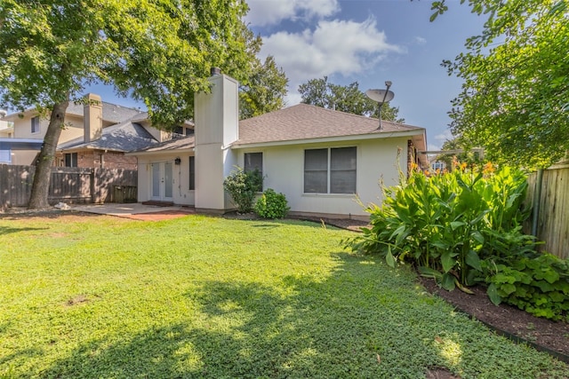 rear view of house featuring a yard