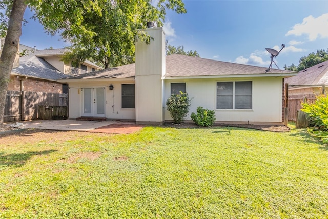 rear view of property featuring a yard, a patio, and french doors