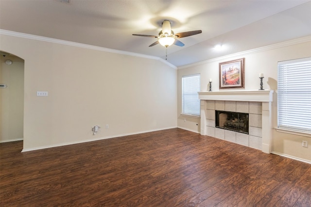 unfurnished living room with a tile fireplace, plenty of natural light, dark hardwood / wood-style floors, and ceiling fan