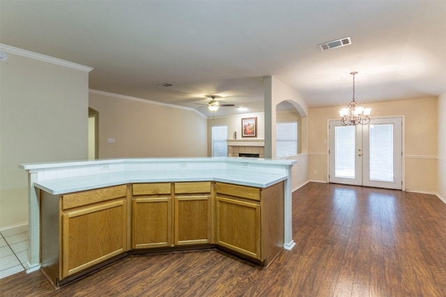 kitchen featuring decorative light fixtures, a fireplace, ceiling fan with notable chandelier, french doors, and dark hardwood / wood-style floors