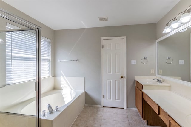 bathroom featuring vanity, a washtub, and tile patterned flooring