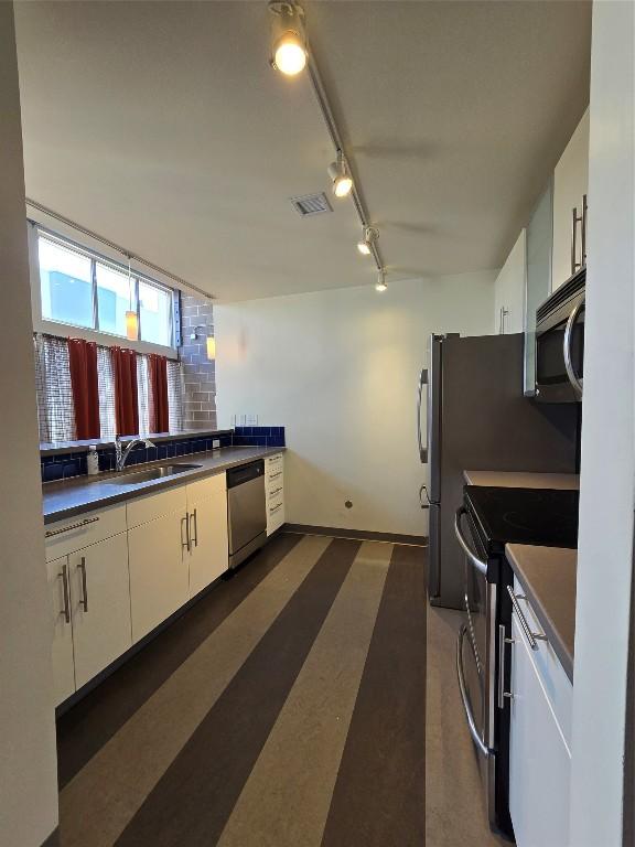 kitchen featuring white cabinetry, appliances with stainless steel finishes, sink, and rail lighting