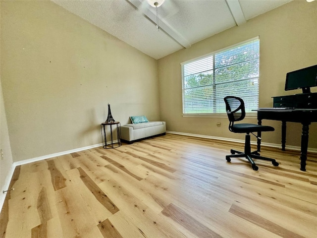 office featuring vaulted ceiling, a textured ceiling, and light hardwood / wood-style floors