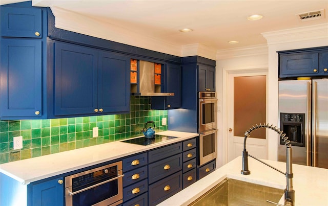 kitchen with blue cabinetry, wall chimney range hood, sink, ornamental molding, and stainless steel appliances