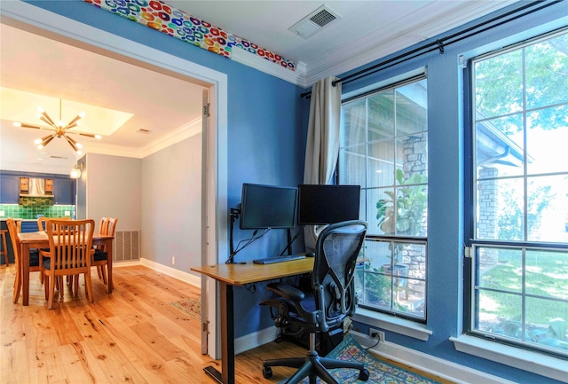 home office with hardwood / wood-style flooring, an inviting chandelier, a wealth of natural light, and ornamental molding