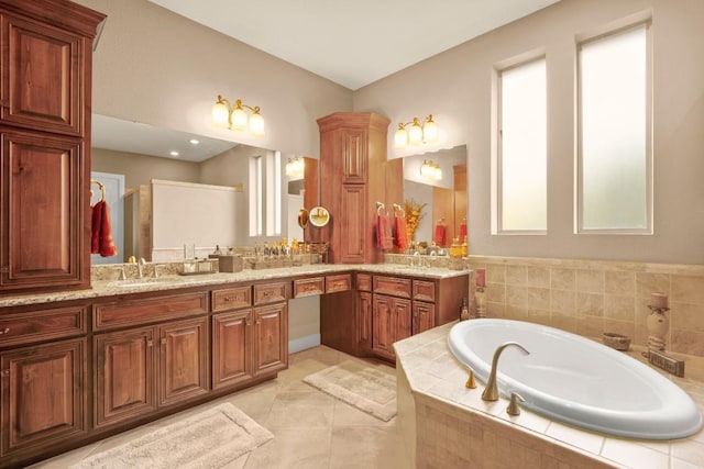 bathroom with vanity, tiled tub, and tile patterned flooring