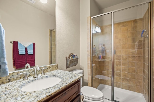 full bath featuring toilet, a stall shower, and vanity