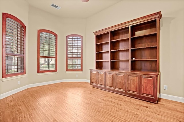 empty room with baseboards, visible vents, and light wood-style floors