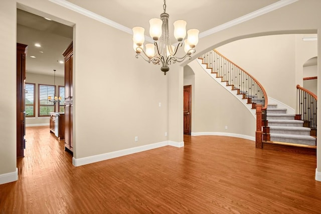 interior space featuring an inviting chandelier, hardwood / wood-style floors, and crown molding