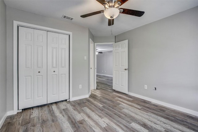 unfurnished bedroom featuring ceiling fan, light hardwood / wood-style floors, and a closet